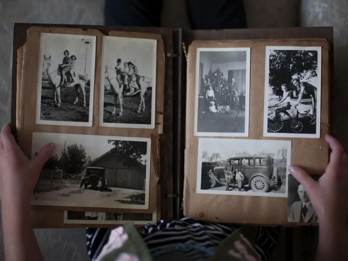 Image Upscaler 4K old photo restoration — person browsing vintage family photo album for restoration